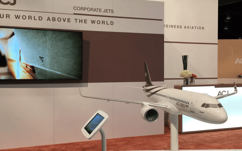 Airbus interactive kiosk beside a display model at a trade show.