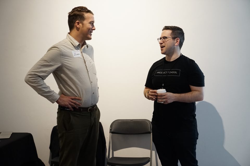 Two trade show exhibitors discussing marketing strategy at a trade show.